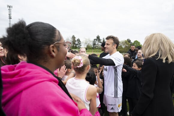 Emmanuel et Brigitte Macron lors d'un match de football caritatif organisé dans le cadre de l'opération Pièces Jaunes dans les Yvelines.