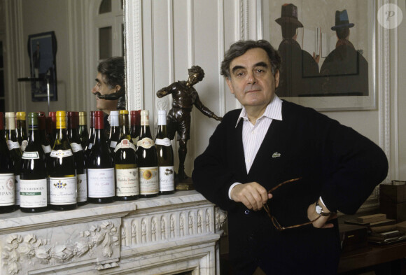 Bernard Pivot à son domicile, posant près d'une cheminée où sont disposées 20 bouteilles de vin de Bourgogne. Le 6 avril 1993 © Michel Marizy via Bestimage