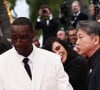 L'acteur d'''Intouchables'' a agacé ses détracteurs en osant faire une série de selfies avec ses amis sur le tapis rouge.
L'acteur français Omar Sy (devant), également membre du jury de la 77e édition du Festival de Cannes, apparaît sur le tapis rouge de la cérémonie d'ouverture du festival à Cannes, dans le sud de la France, le 14 mai 2024.