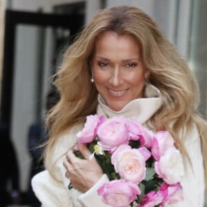 Elle qui pour rappel souffre du syndrome de la personne raide.
Celine Dion rayonnante et très souriante dans un ensemble pull écru et jupe bouffante fleurie salue ses fans à la sortie de son hôtel à New York, le 8 mars 2020 