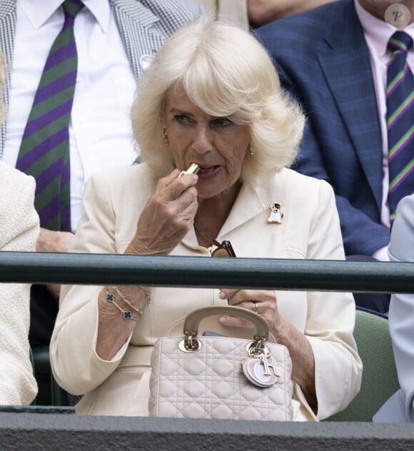 La reine consort d'Angleterre Camilla Parker Bowles touching up her lipstick dans les tribunes de Wimbledon, lors de la 10ème journée du tournoi de tennis. Le 10 juillet 2024  