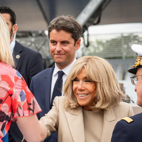 Gabriel Attal, premier ministre, et Brigitte Macron, saluent des fonctionnaires à la cérémonie du 144ème défilé militaire du 14 juillet, jour de la Fête Nationale, à Paris