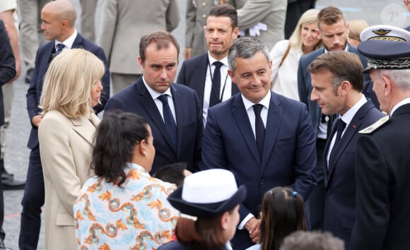 Le Président de la République française Emmanuel Macron et sa femme la Première Dame française Brigitte Macron avec Sébastien Lecornu, ministre des Armées, et Gérald Darmanin, ministre de l'Intérieur et des Outre-mer, lors d'un bain de foule à la cérémonie du 144ème défilé militaire du 14 juillet, jour de la Fête Nationale, à Paris, France, le 14 juillet 2024