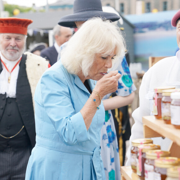 La reine Camilla (Camilla Parker Bowles, reine consort d'Angleterre) goûte du miel lors de l'événement Jersey Expo à Weighbridge Place. Weighbridge Place, Jersey. © Alpha Press/Bestimage