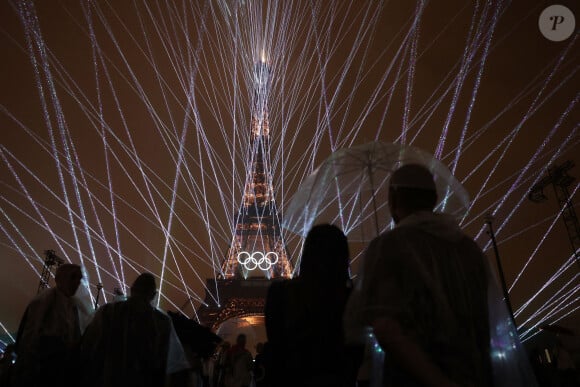 Un spectacle de lumière est vu alors que les anneaux olympiques sur la Tour Eiffel sont illuminés lors de la cérémonie d'ouverture des Jeux olympiques de Paris 2024, le 26 juillet 2024. Xinhua/Li Ming/ABACAPRESS.COM