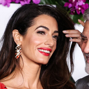 "Réaliser, ça représente une année de tournage ! Nous n'allons pas déraciner nos enfants de l'école et nous balader partout", a confié la star hollywoodienne.
L'avocate libano-britannique Amal Alamuddin Clooney, qui porte une robe Alexander McQueen, et son mari, l'acteur et cinéaste américain George Clooney, arrivent à la première à Los Angeles du film "Ticket To Paradise" d'Universal Pictures, qui s'est tenue au Regency Village Theatre le 17 octobre 2022 à Westwood, Los Angeles, Californie, États-Unis.