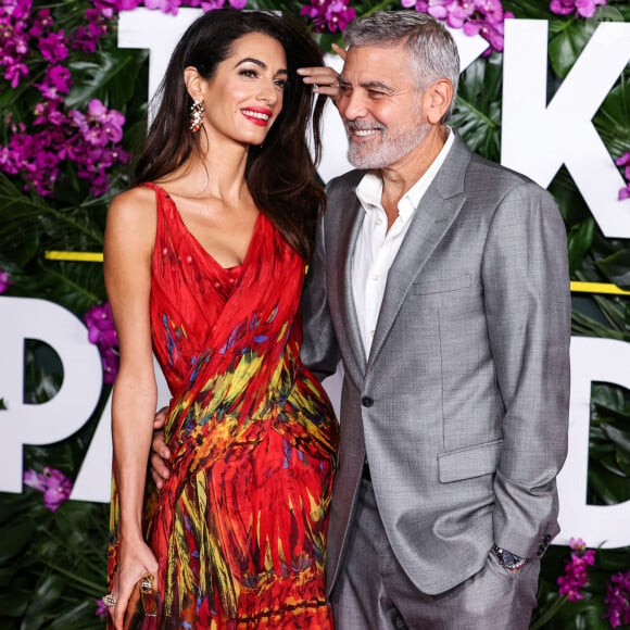 "Réaliser, ça représente une année de tournage ! Nous n'allons pas déraciner nos enfants de l'école et nous balader partout", a confié la star hollywoodienne.
L'avocate libano-britannique Amal Alamuddin Clooney, qui porte une robe Alexander McQueen, et son mari, l'acteur et cinéaste américain George Clooney, arrivent à la première à Los Angeles du film "Ticket To Paradise" d'Universal Pictures, qui s'est tenue au Regency Village Theatre le 17 octobre 2022 à Westwood, Los Angeles, Californie, États-Unis.