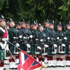 Le roi Charles III d'Angleterre, accueilli par des soldats de la compagnie Balaklava, 5e bataillon du Royal Regiment of Scotland devant le château de Balmoral (Ecosse), où le souverain débute ses vacances d'été, le 19 août 2024.