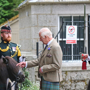 Le roi Charles III d'Angleterre, accueilli par des soldats de la compagnie Balaklava, 5e bataillon du Royal Regiment of Scotland devant le château de Balmoral (Ecosse), où le souverain débute ses vacances d'été, le 19 août 2024.