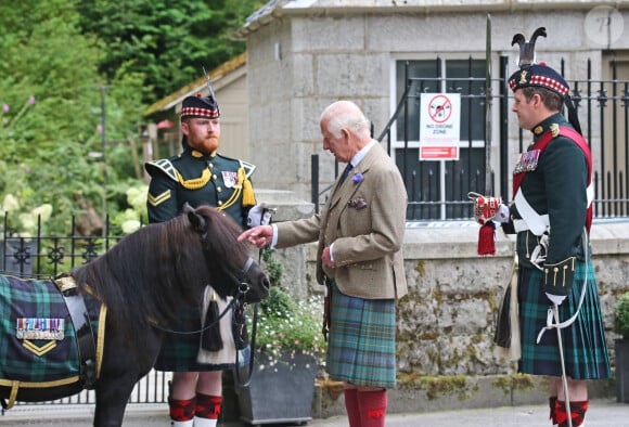 Le roi Charles III d'Angleterre, accueilli par des soldats de la compagnie Balaklava, 5e bataillon du Royal Regiment of Scotland devant le château de Balmoral (Ecosse), où le souverain débute ses vacances d'été, le 19 août 2024.