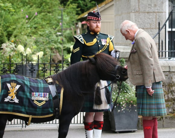 Le roi Charles III d'Angleterre, accueilli par des soldats de la compagnie Balaklava, 5e bataillon du Royal Regiment of Scotland devant le château de Balmoral (Ecosse), où le souverain débute ses vacances d'été, le 19 août 2024.