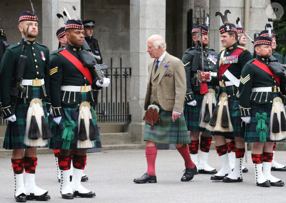 Le roi Charles III d'Angleterre, accueilli par des soldats de la compagnie Balaklava, 5e bataillon du Royal Regiment of Scotland devant le château de Balmoral (Ecosse), où le souverain débute ses vacances d'été, le 19 août 2024.