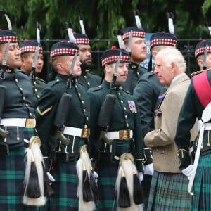 Le roi Charles III d'Angleterre, accueilli par des soldats de la compagnie Balaklava, 5e bataillon du Royal Regiment of Scotland devant le château de Balmoral (Ecosse), où le souverain débute ses vacances d'été, le 19 août 2024.