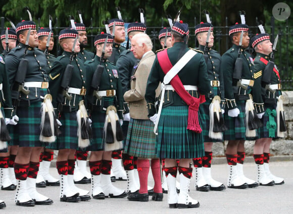 Le roi Charles III d'Angleterre, accueilli par des soldats de la compagnie Balaklava, 5e bataillon du Royal Regiment of Scotland devant le château de Balmoral (Ecosse), où le souverain débute ses vacances d'été, le 19 août 2024.