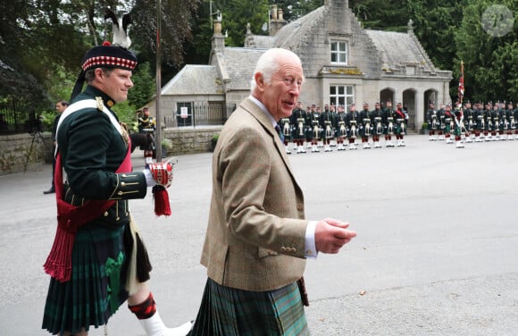 Le roi Charles III d'Angleterre, accueilli par des soldats de la compagnie Balaklava, 5e bataillon du Royal Regiment of Scotland devant le château de Balmoral (Ecosse), où le souverain débute ses vacances d'été, le 19 août 2024.