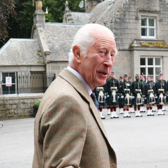 Le roi Charles III d'Angleterre, accueilli par des soldats de la compagnie Balaklava, 5e bataillon du Royal Regiment of Scotland devant le château de Balmoral (Ecosse), où le souverain débute ses vacances d'été, le 19 août 2024.