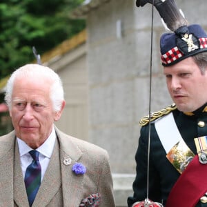 Le roi Charles III d'Angleterre, accueilli par des soldats de la compagnie Balaklava, 5e bataillon du Royal Regiment of Scotland devant le château de Balmoral (Ecosse), où le souverain débute ses vacances d'été, le 19 août 2024.