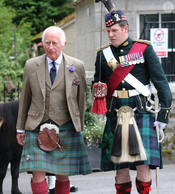 Le roi Charles III d'Angleterre, accueilli par des soldats de la compagnie Balaklava, 5e bataillon du Royal Regiment of Scotland devant le château de Balmoral (Ecosse), où le souverain débute ses vacances d'été, le 19 août 2024.