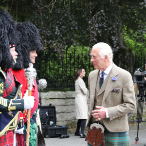 Le roi Charles III d'Angleterre, accueilli par des soldats de la compagnie Balaklava, 5e bataillon du Royal Regiment of Scotland devant le château de Balmoral (Ecosse), où le souverain débute ses vacances d'été, le 19 août 2024.