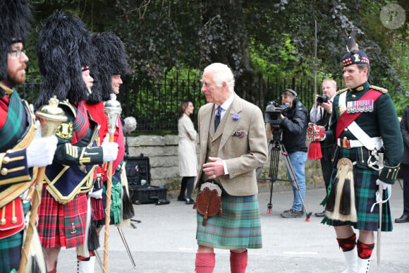 Le roi Charles III d'Angleterre, accueilli par des soldats de la compagnie Balaklava, 5e bataillon du Royal Regiment of Scotland devant le château de Balmoral (Ecosse), où le souverain débute ses vacances d'été, le 19 août 2024.