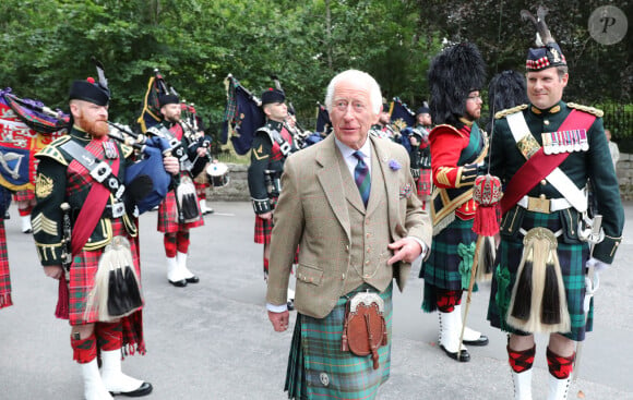 Le roi Charles III d'Angleterre, accueilli par des soldats de la compagnie Balaklava, 5e bataillon du Royal Regiment of Scotland devant le château de Balmoral (Ecosse), où le souverain débute ses vacances d'été, le 19 août 2024.