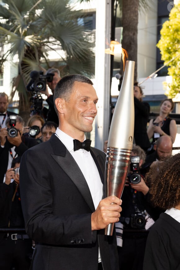 Alexis Hanquinquant et la flamme Olympique - Montée des marches du film « Marcello Mio » lors du 77ème Festival International du Film de Cannes, au Palais des Festivals à Cannes. Le 21 mai 2024 © Jacovides-Moreau / Bestimage