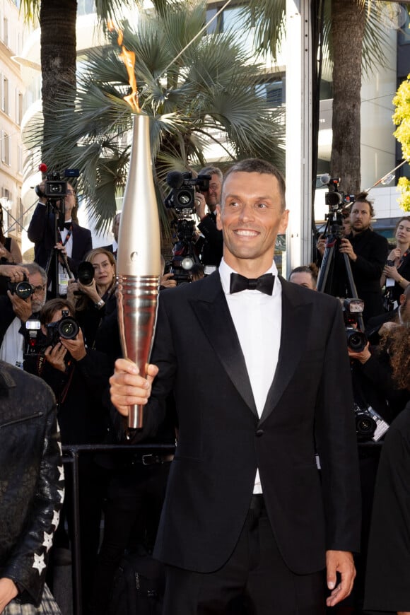 Alexis Hanquinquant et la flamme Olympique - Montée des marches du film « Marcello Mio » lors du 77ème Festival International du Film de Cannes, au Palais des Festivals à Cannes. Le 21 mai 2024 © Jacovides-Moreau / Bestimage