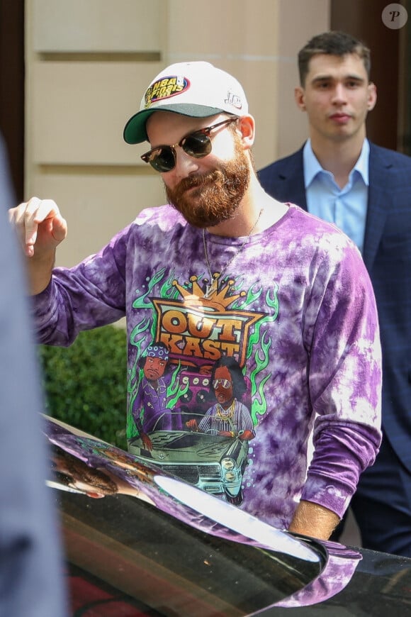 René-Charles Angélil, porte un t-shirt Outkast, et sa compagne Angelique Weckenmann à la sortie de l'hôtel Royal Monceau avant l'ouverture des Jeux Olympiques (JO) Paris 2024 à à Paris, France, le 24 juillet 2024. 