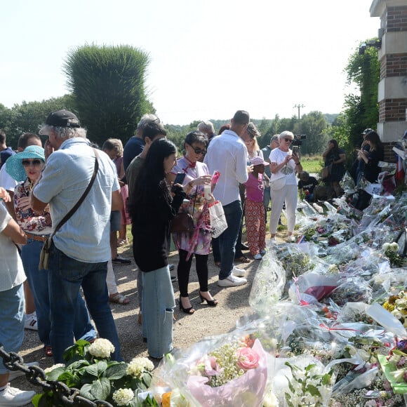 Les fans rendent hommage à Alain Delon devant la grille de sa propriété à Douchy-Montcorbon pendant ses obsèques le 24 août 2024.  Fans pay tribute to Alain Delon in front of the gate of his property in Douchy-Montcorbon during his funeral on August 24, 2024. 