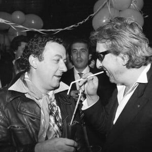 Archives - En France, à Paris, lors d'une fête, Coluche parlant avec Serge Gainsbourg le 17 décembre 1981. © Michel Croizard via Bestimage