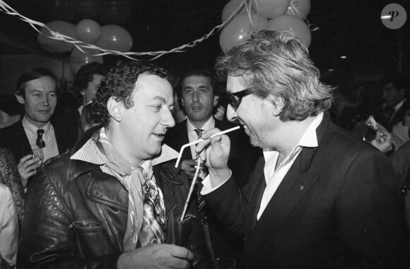 Archives - En France, à Paris, lors d'une fête, Coluche parlant avec Serge Gainsbourg le 17 décembre 1981. © Michel Croizard via Bestimage