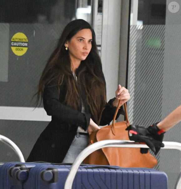 Olivia Munn et son compagnon John Mulaney arrivent, main dans la main, à l'aéroport JFK à New York, le 20 juin 2024.