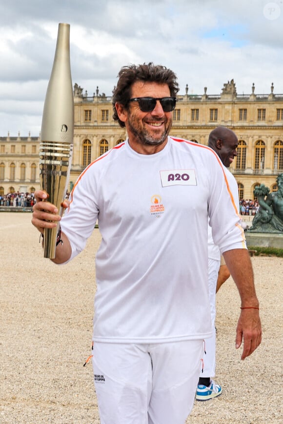 Le chanteur et acteur Patrick Bruel porteur de la flamme olympique des Jeux Olympiques de Paris 2024 (JO) au château de Versailles dans les Yvelines, France, le 23 juillet 2024. © Dominique Jacovides/Bestimage 