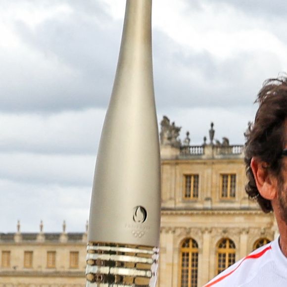 Le chanteur et acteur Patrick Bruel porteur de la flamme olympique des Jeux Olympiques de Paris 2024 (JO) au château de Versailles dans les Yvelines, France, le 23 juillet 2024. © Dominique Jacovides/Bestimage 