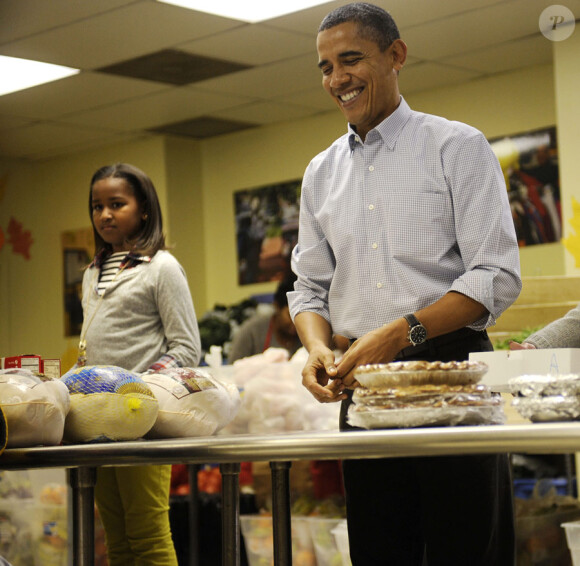 Barack Obama et sa fille Sasha offre son aide aux personnes défavorisées à Washington le 24 novembre 2010