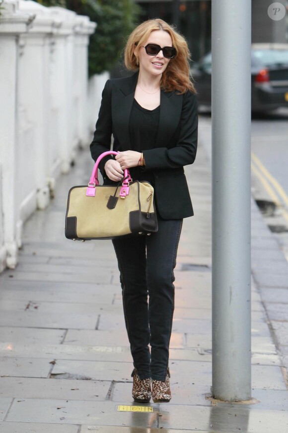 Kylie Minogue adopte le total look black mais le nuance avec des bottines léopard et un sac en toile qui dynamise sa silhouette. Bravo !