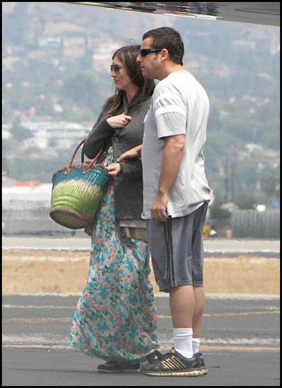 Adam Sandler très tendre avec sa femme Jacqueline Titone alors qu'ils prennent l'avion avec leurs deux filles Sunny et Sadie à l'aéroport de Burbank le 4 juin 2011