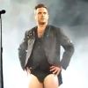 Robbie Williams toujours aussi chic en plein concert des Take That à Cardiff, le 15 juin 2011. Quitte à déchirer son pantalon, autant s'en débarrasser.