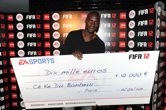 Omar Sy et le chèque de la victoire à la soirée de lancement de FIFA 12 au VIP ROOM à Paris le 19 septembre 2011