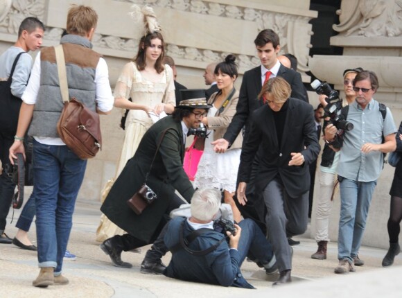 Sean Lennon, chevaleresque, aide un photographe à se relever en marge du défilé Chanel le 4 octobre 2011 au Grand Palais