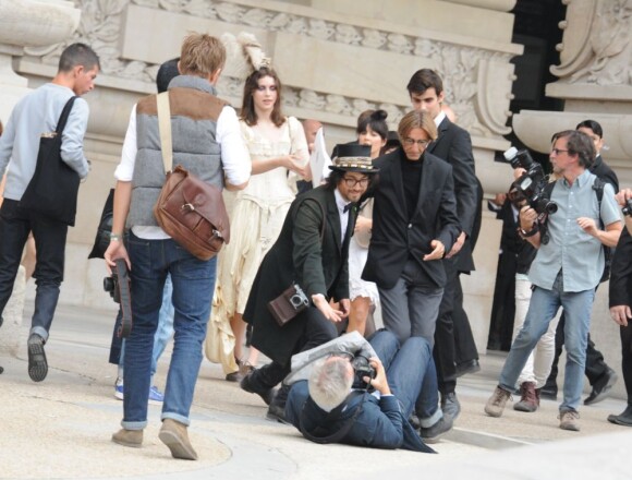 Sean Lennon aide un photographe à se relever en marge du défilé Chanel le 4 octobre 2011 au Grand Palais