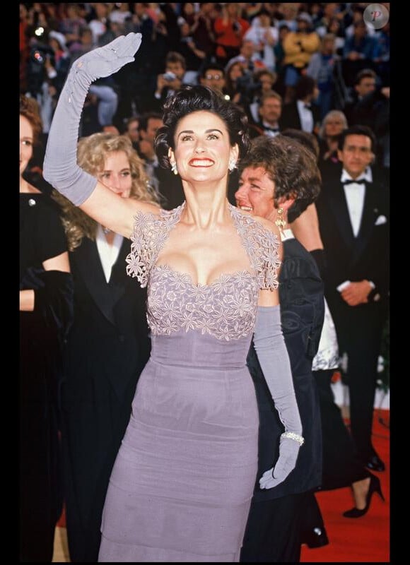 Demi Moore, tout sourire à son arrivée aux Oscars, aurait mieux fait de choisir une autre robe... et une autre coiffure. Los Angeles, le 1er avril 1992.