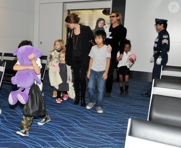 Angelina Jolie, Brad Pitt et leurs enfants Madox, Pax dissimulé derrière une énorme peluche, Zahara, Shiloh et les jumeaux Vivienne et Knox le 10 novembre 2011 à l'aéroport international de Haneda au Japon