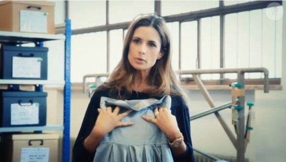 Livia Firth joue à la créatrice de mode dans un atelier, avec sa robe dans les bras. 