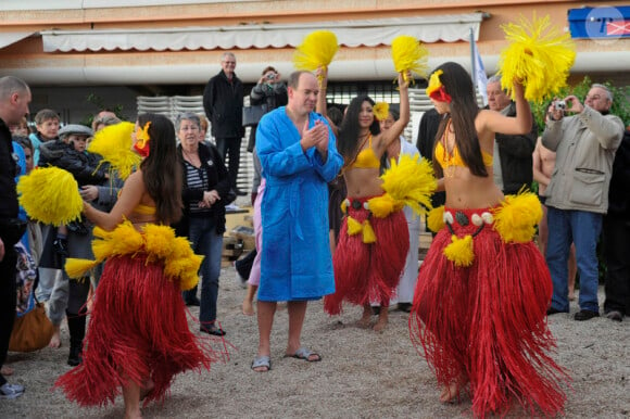 Le Prince Albert de Monaco et les danseuses hawaïennes lors du traditionnel bain de charité pour Noël, à Monaco le 18 décembre 2011