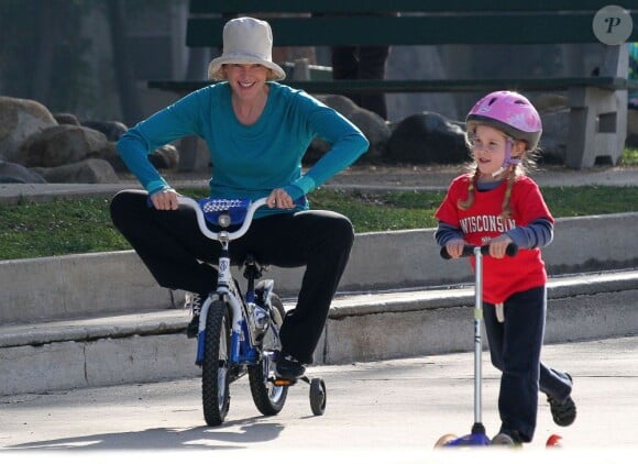 Eden assure sur sa trottinette pendant que Marcia Cross et Savannah font du vélo dans un parc de Santa Monica le 29 décembre 2011 