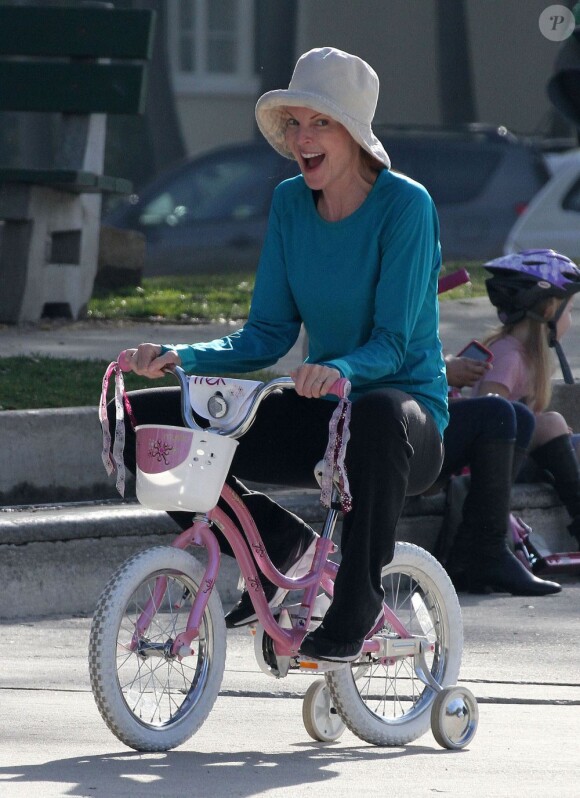 Marcia Cross s'amuse comme une folle sur le vélo d'une de ses jumelles Eden et Savannah dans un parc de Santa Monica le 29 décembre 2011 