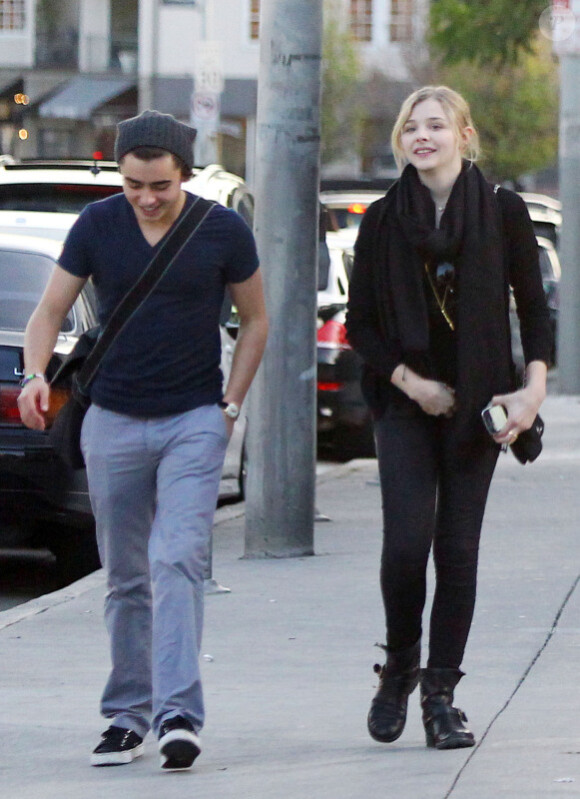 Chloë Moretz, ravissante dans un total look noir au côté d'un ami se promènent dans les rues de West Hollywood le 8 janvier 2012