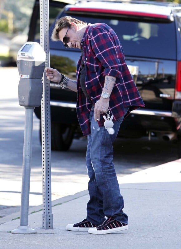 Un petit tour au parcmètre pour Johnny Hallyday à Los Angeles, le 8 février 2012.