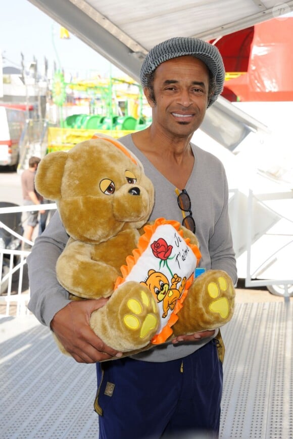 Yannick Noah et un ours en peluche à la conférence de presse de la Foire du Trône 2012, à Paris le 26 mars 2012